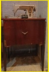Linda e Antiga máquina de costura marca Singer em belo gabinete de madeira com pés ao estilo década de 60