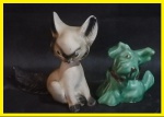 Par de escultura representando raposa e cachorro sendo o maior de material sintético e o menor de porcelana. Med. maior 15cm, menor 10cm