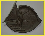 BRONZE -  Medalhão de bronze de parede com desenho ao centro em alto relevo com tripulante com seu chapéu na parte de trás barco a vela. Med. 24cm x 20cm