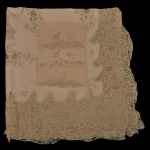 Belíssima toalha de mesa para jantar em tecido (linho e renda) de cor neutra (bege claro) emoldurada por uma borda geométrica recortada e cercado por uma aba externa texturizada. Medindo 337 x 186 cm, acompanhada de 22 guardanapos medindo 38 x 34 cm.