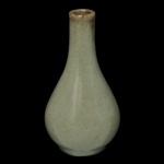 CHINA. Final do séc. XIX - Vaso piriforme em porcelana chinesa, revestido por coberta celadon de cor verde água. Bojo abaulado encimado por gargalo reto e longo. Base retraída circular. 17 x 7 cm.