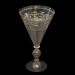 Taça em cristal com haste trabalhada e decoração colorida no bojo em formato cônico. 17 x 10 cm.