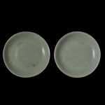 CHINA. Séc. XIX - Par de tigelas circulares em porcelana chinesa lisa, revestidas por coberta celadon de cor esverdeada. Marcas borradas e ilegíveis sob as bases. 13 cm.
