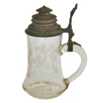 Tankard em vidro translucido e liso. Tampa articulada feita de estanho (pewter) e uma alça de vidro moldado.18 x 12 cm.