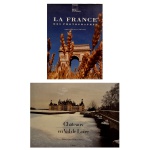 Lote constando de dois livros ilustrados sobre a França e suas famosas paisagens arquitetônicas: A) La France des Photographes: O livro de cima é uma coletânea fotográfica intitulada La France des Photographes (com o subtítulo original de "Trois Jours en France"). A capa traz uma fotografia clássica do Arco do Triunfo em Paris, enquadrada por ramos de trigo em primeiro plano. B) Châteaux en Val de Loire, foca nas residências históricas da região do Vale do Loire. A imagem da capa destaca o majestoso Castelo de Chambord (Château de Chambord) refletido nas águas adjacentes sob uma atmosfera de névoa ou tom sépia.