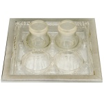 Conjunto de peças composto por uma bandeja com 2 recipientes para sal e pimenta. Travessa de formato quadrangular em vidro com borda em metal prateado. Acompanha 1 saleiros e 1 pimenteiro.  20 x 20 cm (bandeja).  6 x 5 cm (potes).