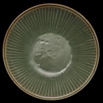 Medalhão circular em porcelana chinesa, revestido por coberta celadon de cor verde, moldado e ornado por gomos. Apresenta no centro rosácea com estilização floral. Peça do séc. XX no estilo da dinastia Ming. 9 x 40 cm.