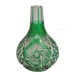 Vaso na forma de moringa em cristal doublé (ou overlay) verde esmeralda, ricamente lapidada à mão com motivos geométricos e florais como estrelas e palmas. Esse estilo de produção artística sobrepõe uma camada de cristal colorido a uma base de cristal translúcido. 20 x 14 cm.