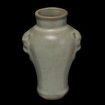 Vaso em porcelana chinesa, de formato balaústre, revestido por coberta celadon de cor verde água. Bojo abaulado, ladeado por pegas incisas com cabeças de monstros. Gargalo reto e liso. Base retraída circular. 16 x 10 cm. Peça decorativa e de design moderno.