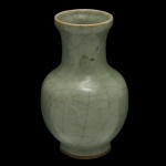 Vaso balaústre em porcelana chinesa, revestido por coberta celadon de cor verde água. Bojo abaulado, encimado por gargalo ladeado em corneta e borda saliente e revirada. Base retraída circular. China. Séc. XX. 16 x 10 cm.