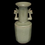Vaso em porcelana chinesa, revestido por coberta celadon de cor verde água. Bojo reto, encimado por gargalo ladeado por pegas no formato de dragões. Borda saliente e revirada. Base retraída circular. 14 x 7 cm. Arte decorativa e de design moderno.