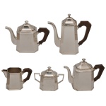 SAINT JAMES - Conjunto para chá e café Art Déco em metal espessurado a prata, da manufatura nacional. St. James. Corpo geométrico octogonal de linhas retas e limpas, Cabo em madeira escura, projetado para isolar o calor e garantir um manuseio seguro. Constando de 5 peças, sendo: Bule para café (24 x 22 cm), bule p/ chá (18 x 23 cm), leiteira (18 x 23 cm), cremeira (11 x 17 cm) e açucareiro (15 x 17 cm).
