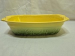 Travessa retangular em cerâmica vitrificada com relevos de flores, verde e amarela. Medindo 32cm x 20cm x 8cm de altura.