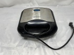 Sanduicheira Elétrica Westinghouse: Sanduicheira elétrica marca Westinghouse, modelo WKSMSW51, em plástico preto com detalhe em aço escovado, placas internas antiaderentes para dois sanduíches, voltagem 127V e potência de 850W, apresentando marcas estéticas de uso e oxidação na chapa externa. Funcionando perfeitamente.