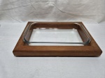 Travessa retangular em vidro temperado com suporte de madeira. Medindo a travessa 35cm x 21cm x 5cm de altura. Com leves bicados.