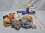 Lote de diversas lãs coloridas e agulhas de crochê.
