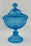 Compoteira de coleção em vidro na cor azul, decoração em alto relevo, com motivos florais e arabescos, borda ondulada. Corpo apoiado sobre pé circular decorado. Medindo: 24 x 15,5 cm 
