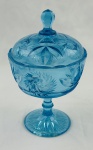 Compoteira de coleção em vidro na cor azul, decoração em relevo, com motivos florais e geométricos, borda ondulada. Corpo apoiado sobre pé circular decorado. Medindo: 22 x 13 cm. apresenta bicados e batida seca, que não compromete o uso e beleza da peça. 