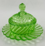 Manteigueira de coleção em vidro na cor verde, decoração em relevo espiralados e canelados. Medindo: 10,5 x 13 cm.