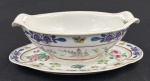 China. Molheira em porcelana chinesa esmaltados com rica decoração policroma de motivos florais, folhagens e borboletas; detalhes em azul e bordô ao gosto Famille Rose. Marcado ao fundo em azul. Medindo: 8 x 23 x 16 cm.