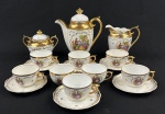 Mauá. Serviço para café em porcelana esmaltada na cor branca, decoração policroma com medalhão de cena galante ao centro e ricos detalhes em ouro. Composto de bule, leiteira, açucareiro, 8 xícaras para café com 6 pires. Medindo respectivamente; 17,5 x 16 cm, 11 x 11 cm, 11 x 12 x 9 cm. uma xícara com fio de cabelo.