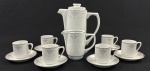 Studio Rachel, Los Angeles Times. Conjunto para café em porcelana esmaltada na cor branca, com delicada decoração floral em tons de cinza, azul e marrom. Filetes em prata. Composto de bule, leiteira e seis xícaras com seus pires. Manufatura no verso. Medindo:  20,5 x 17 cm e 10 x 12 x 6 cm.