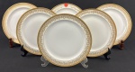 Limoges, France. Seis pratos para sobremesa em porcelana esmaltada na cor branca com rica decoração em douração, composta por faixa ornamental de inspiração neoclássica, formada por reservas ovais com motivos florais estilizados, folhagens e arabescos, dispostos em composição rítmica e simétrica. Apresenta frisos e filetes concêntricos em ouro, acabamento de grande elegância e requinte. Manufatura no verso. Medindo: 21,5 cm. Um com desgastes.