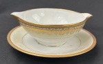 Limoges, France. Molheira em porcelana esmaltada na cor branca com rica decoração em douração, composta por faixa ornamental de inspiração neoclássica, formada por reservas ovais com motivos florais estilizados, folhagens e arabescos, dispostos em composição rítmica e simétrica. Apresenta frisos e filetes concêntricos em ouro, acabamento de grande elegância e requinte. Manufatura no verso. Medindo: 7 x 18 cm.