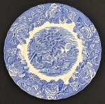 Woods Ware, wood & Sons, England. Prato decorativo em faiança inglesa esmaltado nas cores azul e branca, rica decoração floral na borda e medalhão de cena de campo ao centro, dito fazendinha. Bordas levemente onduladas. Manufatura verso. Medindo: 25 cm