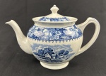 Woods Burslem, England. Bule em porcelana inglesa, padrão colonial, esmaltado nas cores azul e branco, com rica decoração floral e centro com paisagem de campo. Manufatura no verso. Medindo: 16,5 x 24 cm.