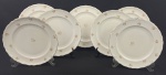 EPIAG. Sete pratos rasos em porcelana tcheca na cor marfim, com decoração floral policromada, detalhes na borda em relevo e filetes em ouro, manufatura no verso. Medindo: 24 cm.