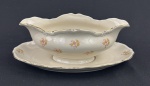 EPIAG. Molheira e espinheira em porcelana tcheca na cor marfim, com decoração floral policromada, detalhes na borda em relevo e filetes em ouro, manufatura no verso. Medindo: 9 x 22 x 15 cm.