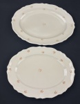 EPIAG. Duas travessas em porcelana tcheca na cor marfim, com decoração floral policromada, detalhes na borda em relevo e filetes em ouro, manufatura no verso. Medindo: 38 x 39 cm e 41 x 30,5 cm.