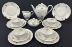 Bavaria. Conjunto para chá em porcelana branca esmaltada, decoração floral em ouro. Composto de bule, leiteira, açucareiro, 4 xícaras para chá e 6 pratos para sobremesa. Manufatura no verso. Medindo: 22 x 25 x 14 cm, 9 x 13 x 9 cm, 10 x 15 x 11 cm e 19 cm. Alça de uma xícara quebrada.