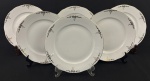 Seis pratos rasos em porcelana esmaltada na cor branca, decoração floral e filetes em ouro. Bordas onduladas. Medindo; 24 cm.