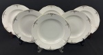 Seis pratos fundos em porcelana esmaltada na cor branca, decoração floral e filetes em ouro. Bordas onduladas. Medindo; 4 x 24 cm.