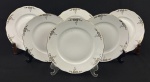 Seis pratos para sobremesa em porcelana esmaltada na cor branca, decoração floral e filetes em ouro. Bordas onduladas. Medindo; 19 cm.