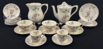 Alfred Meakin, England. Conjunto de peças em faiança esmaltada e policromada. Bordas onduladas e filetada a ouro. Composto de bule, leiteira, 3 xícaras de chá com 6 pires e 2 xícaras de café com 9 pires. Manufatura no verso. Medindo: 19 x 20 x 13 cm e 16 x 17 cm. Apresentam desgastes. Pequeno restauro em um xícara de café 3 pires de café, 3 de chá e xícaras de chá com manchas.