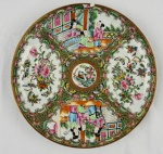 Famille Rose. Prato decorativo em porcelana chinesa, com rica policromia de flores, folhagens e pássaros. Parte central apresenta cenas figurativas em ambiente tradicional chinês com detalhes dourados e borda finamente ornamentada. Medindo: 22 cm. Apresenta bicado/ lasca seguido de fio de cabelo.