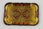 Bandeja veneziana em madeira, de formato retangular com cantos recortados e composição ornamental em relevo. Apresenta rica decoração com pintura em tons de dourado e vermelho/alaranjado. Medindo: 25,5 x 17,5 cm.