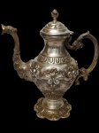 Imponente bule em metal espessurado a prata no estilo "ROCAILLE" decorado com cinzelados de conchas, palmas e volutas. Alça ornamentada. Medindo: 32 cm.