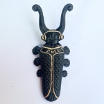Descalçadeira de botas JIMES. Ferro fundido em forma de escaravelho. A Jimes foi uma tradicional fundição brasileira famosa por produzir uma grande variedade de objetos decorativos e utilitários em ferro fundido e bronze ao longo do século XX. Esse utensílio tradicional serve para ajudar a descalçar botas e sapatos pesados sem precisar se abaixar: basta pisar na parte traseira do besouro e encaixar o calcanhar entre as antenas para puxar o pé para fora.