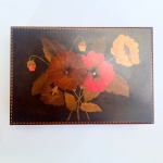 Antiga caixa porta jóias em madeira nobre com rica marchetaria floral sobre 4 pés. Década de 1960. Interior forrado com cetim laranja com desgastes. Med 25x17x7cm. 