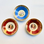 Porcelana Pedro II Rio de Janeiro - séc. XX - Três pratinhos da tradicional fábrica de porcelanas Pedro II, dois com imagens de damas e um com cena galante com tons vibrantes em vermelho e azul e douração. Med 10 cm diâmetro. 