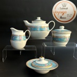 Schmidt - Conjunto para chá em porcelana nacional vitrificada e ornamentada com delicado barrado azul com flores em policromia e douração da linha Voyage Barroco. Composto por bule 15x22cm, leiteira 21,5x12cm, açucareiro 12x11cm e manteigueira 15x7,5cm.