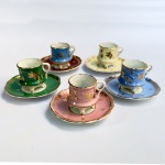 Porcelana Schmidt - Conjunto de cinco xícaras para café em porcelana de cores diversas com decoração à ouro elevadas por três pés. Década de 1950. Uma xícara e pires de cores diferentes. 