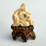Pequena escultura em marfim representando BUDA com base em madeira esculpida. Séc XIX. Med 7,5x5cm. 