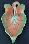 Antiga fruteira em metal em formato de folha nas cores vermelha e verde com dois pés em metal com curvatura. Medindo: 16 x 31 x 57 cm.