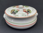 Barão do Rio Branco. Grande e antiga tigela em porcelana branca com tampa tendo pintura de 4 galos envolvida por frisos circundantes nas cores verde e vermelho contendo duas alças nas laterais. Medindo: 15 x 30 cm.