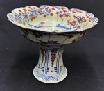 Fruteira ou centro de mesa em porcelana oriental celadon apresentando tom  azul-acinzentado, característico desse tipo de porcelana com pintura floral ´policromada apoiada sobre  pé alto em pedestal. Possui inscrição com caracteres asiáticos visível na parte inferior que quer dizer  Período Zhengde da Dinastia MING. A inscrição é uma marca de reinado inspirado na Dinastia MING, especificamente o imperador ZHENGDE, que reinou entre 1506  1521. Acreditamos se tratar de uma perfeita réplica desse período. Medindo: 25 x 30 cm.